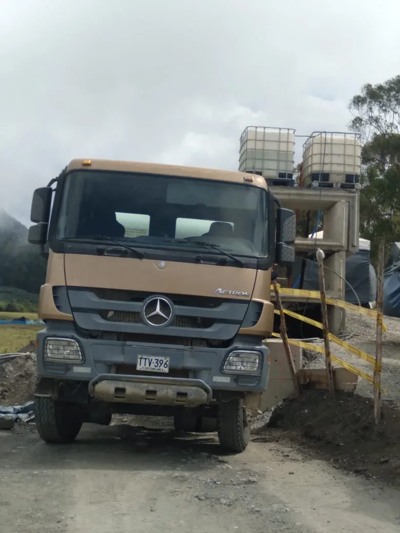 Camion mixer estacionado en una obra en zona de montana junto a una planta de mezcla