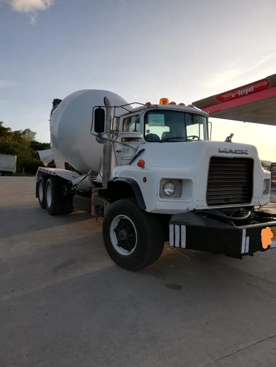 Camion mixer Mack blanco al atardecer durante una jornada de despacho